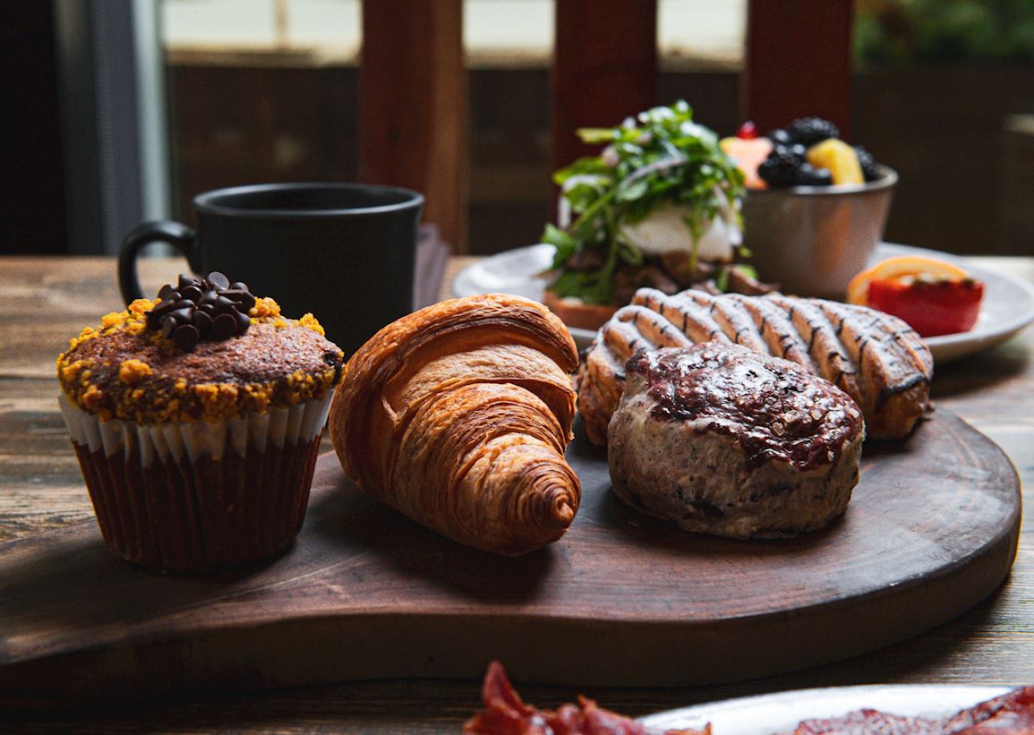 breakfast pastries, bowl of fruit, cup of coffee